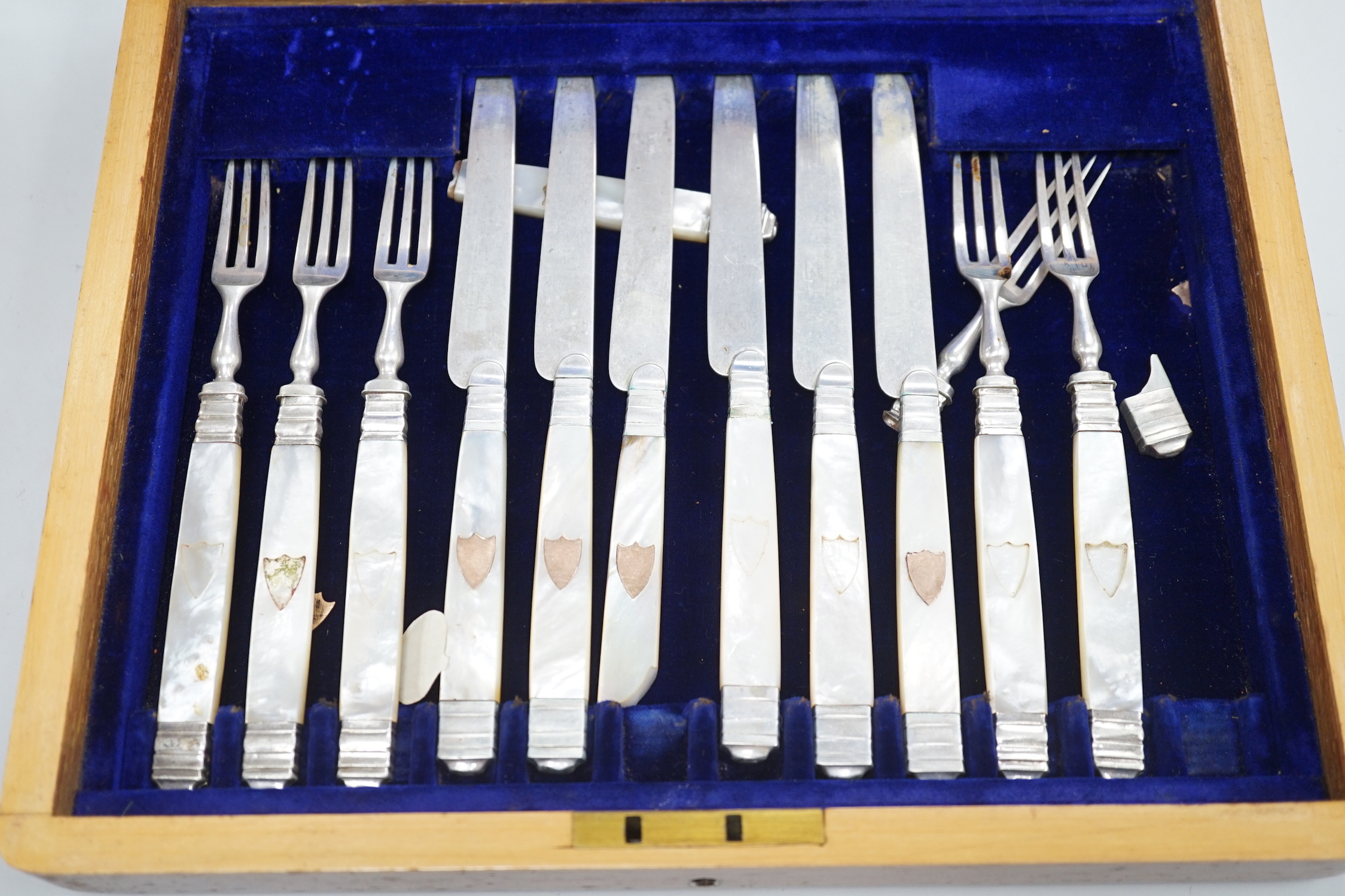 A cased set of twelve pairs of 19th century French mother of pearl handled white metal dessert eaters (one fork a.f.).